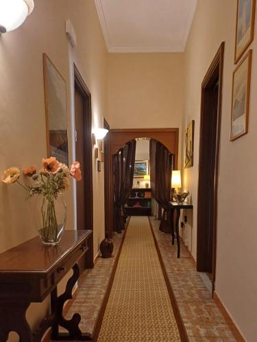 a hallway with a vase of flowers on a table at La Casa in Piazza in Maratea