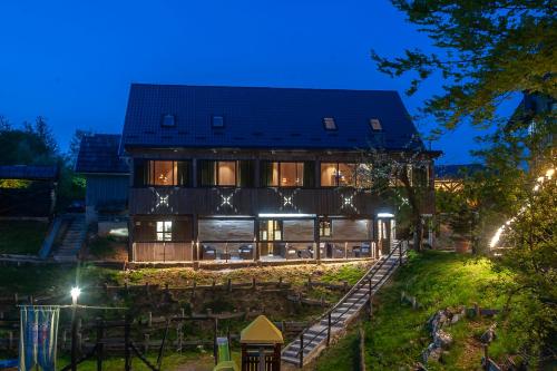 a large house with a building at night at Lakeside Hotel Plitvice in Plitvička Jezera