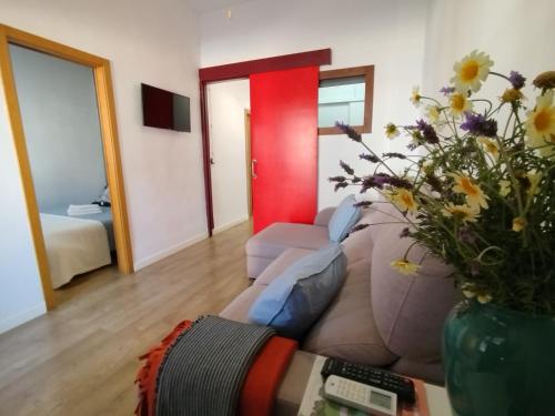 a living room with a couch and a vase with flowers at Casa de Mar in Barrio-Mar