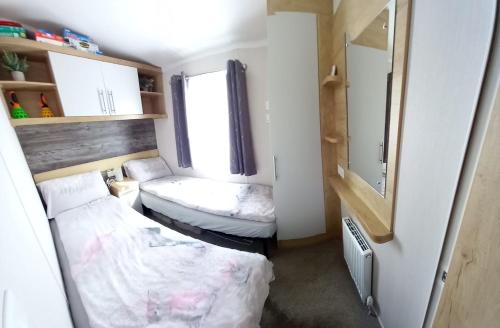 a small room with two beds and a window at Chill Out at Seton Sands in Port Seton