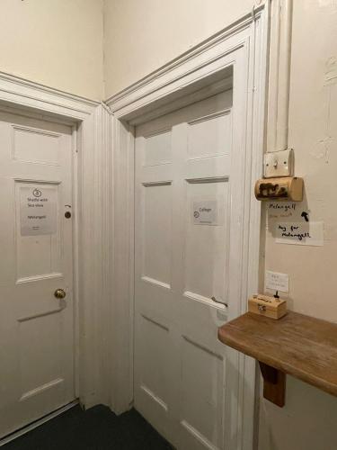 a white door in a room with a wooden table at Bryn Awel in Aberystwyth