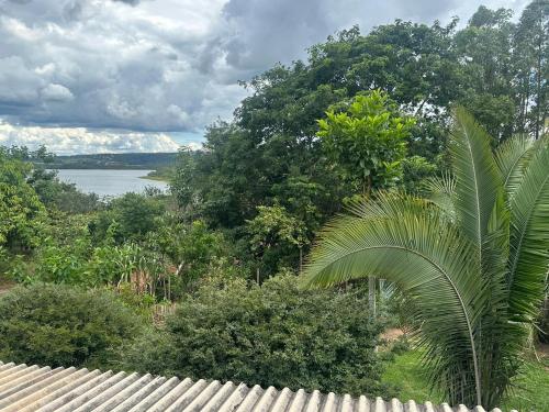 Blick auf das Wasser von einem Haus mit einer Palme in der Unterkunft Casa Ipê Amarelo in Abadiânia