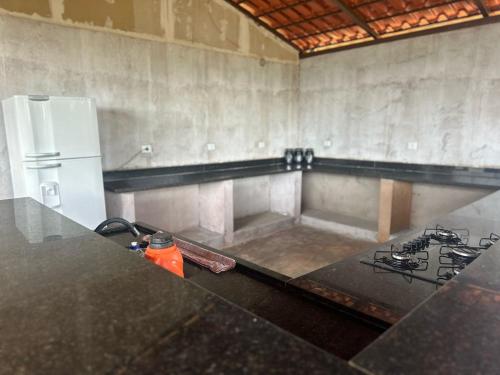 eine Küche mit Herd und weißem Kühlschrank in der Unterkunft Casa Ipê Amarelo in Abadiânia