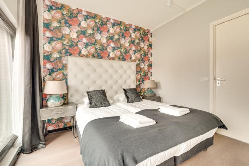 a bedroom with a large bed with a floral wall at Hotel Zilt in Vlissingen