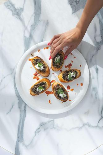 a person holding a plate with four oysters on it at Levatio Suites Muscat, a member of Radisson Individuals in Muscat