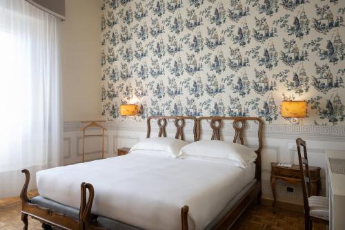 a bedroom with a bed with a blue and white wallpaper at Palace Hotel in Viareggio
