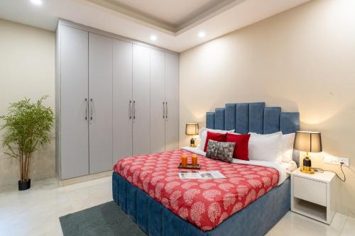 a bedroom with a large bed with a red blanket at Homlee-Anupam 3BHK-Lift-Parking-Saket-Max Hospital in New Delhi