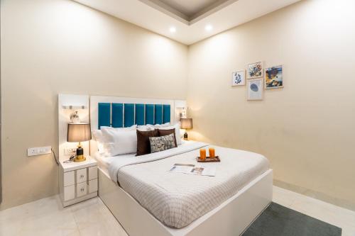 a bedroom with a large white bed with a blue headboard at Homlee-Anupam 3BHK-Lift-Parking-Saket-Max Hospital in New Delhi