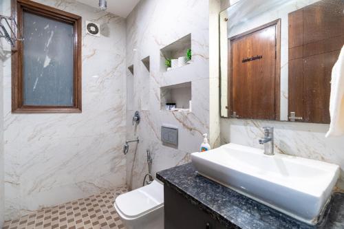 a white bathroom with a sink and a toilet at Homlee-Anupam 3BHK-Lift-Parking-Saket-Max Hospital in New Delhi