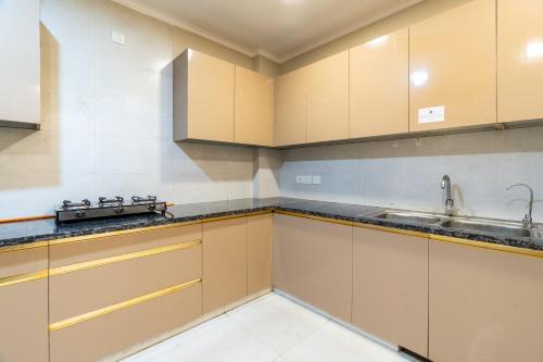 a kitchen with wooden cabinets and a sink at Homlee-Anupam 3BHK-Lift-Parking-Saket-Max Hospital in New Delhi