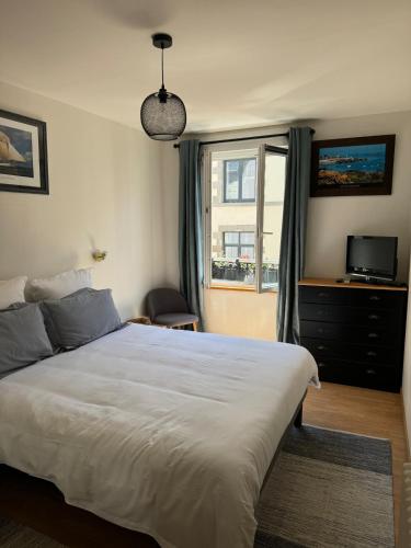 une chambre avec un grand lit et une fenêtre dans l'établissement Appartement Granville hyper centre, à Granville