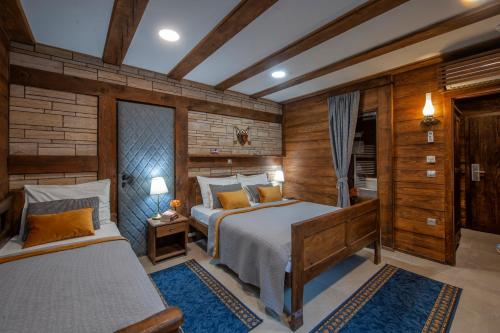 a bedroom with two beds and wooden walls at Lakeside Hotel Plitvice in Plitvička Jezera