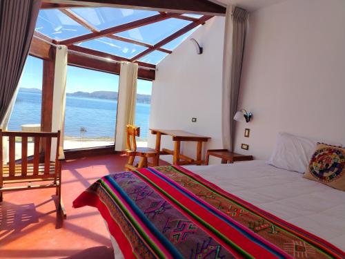 a bedroom with a bed and a view of the ocean at Luquina Experience Lodge in Luquina