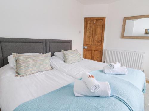 two twin beds with towels on top of them at Brycheiniog View in Brecon