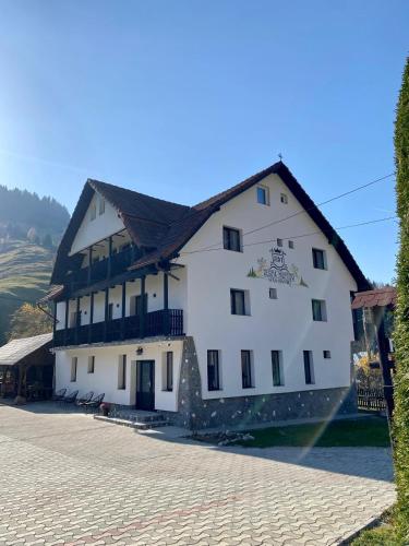 a large white building with a black roof at Regina Munților Spa&Confort in Moieciu de Sus