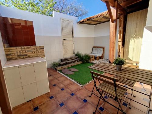 a patio with a table and chairs and a lawn at Casa de Mar in Barrio-Mar