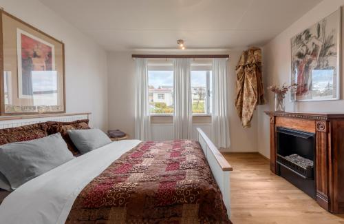 a bedroom with a large bed and a fireplace at Art & Nature Retreat in Iceland - The Crib Rocks in Borgarnes
