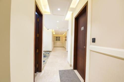 a hallway with a door and a hallway with a rug at FabHotel Prime Siya Residency - Nr Karkardooma Metro Station in New Delhi