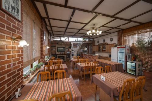 a restaurant with wooden tables and chairs and brick walls at Alpinist Hotel in Bishkek