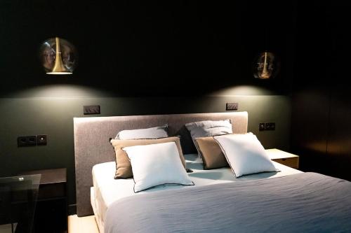 une chambre avec un grand lit avec des draps et des oreillers blancs dans l'établissement Amazing appartements on Champs-Elysées, à Paris