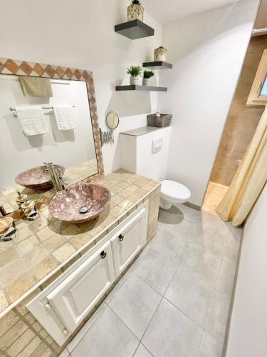 une salle de bain avec un lavabo et un miroir dans l'établissement Appartement avec piscine 8 personnes, à Porto-Vecchio