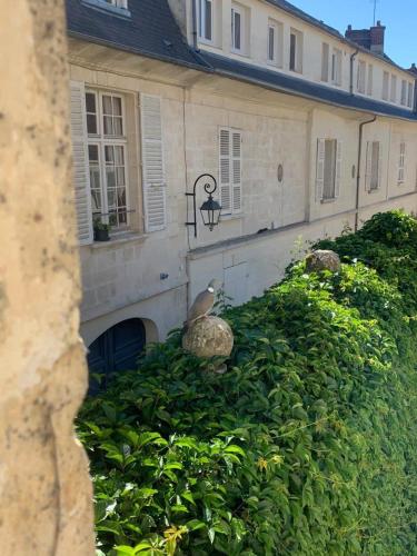 a bird sitting on a bush in front of a building at La Maison Saint Joseph in Crépy-en-Valois