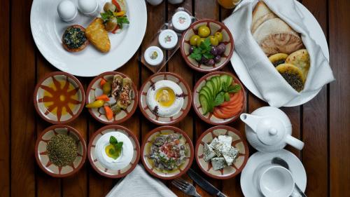 a wooden table with plates of food on it at The Abdali Boulevard Hotel in Amman