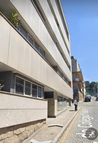 a woman walking down a street next to a building at Apartamento Centro Guimarães com Vista Panorâmica in Creixomil