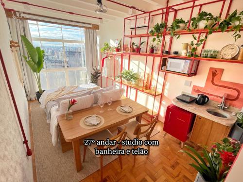 a bedroom with a bed and a table and a sink at Vem pro Copan in Sao Paulo