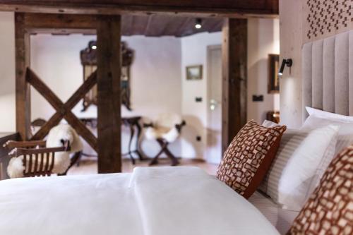 a bedroom with a bed with white sheets and pillows at Hotel Julian Alps in Zgornje Gorje