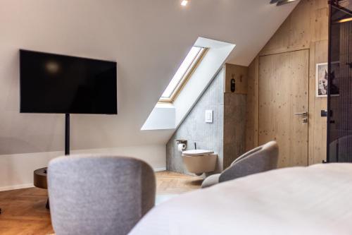 a room with a table and chairs and a tv at Hotel Julian Alps in Zgornje Gorje