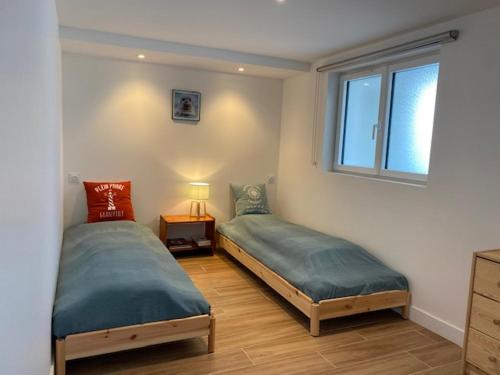 une chambre avec deux lits et une fenêtre dans l'établissement La Foliotte - Appartement Jacuzzi, à Jullouville