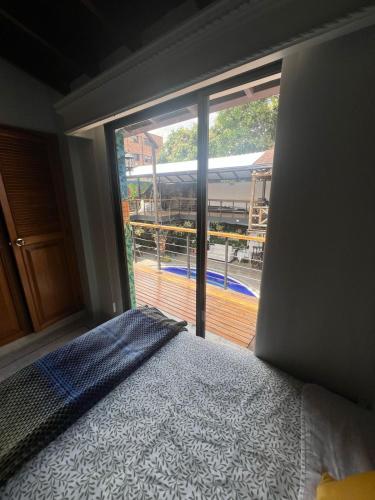 a bedroom with a bed and a large window at Casa Boutique La Corona Medellin in Envigado