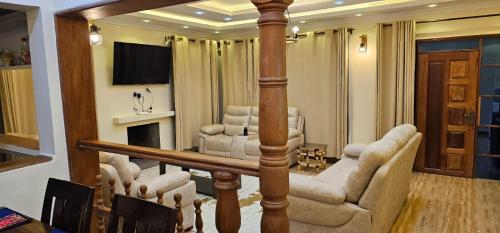 a living room with couches and a television in a room at Eagles Nest in Ol Kalau Station