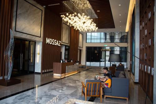 a person sitting at a table in a lobby at 13 Mossaz skypool 5mins to 1U and Ikea atEmpire City by Light House in Petaling Jaya