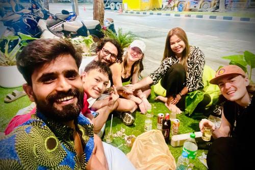 a group of people sitting on the grass at Lemon Tree Hostel Khaosan in Bangkok