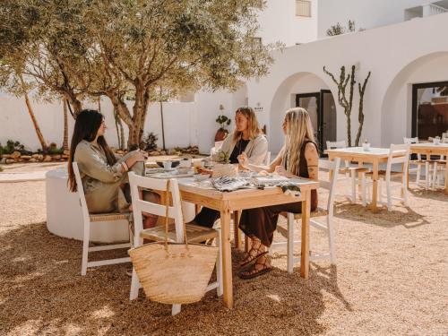 un grupo de mujeres sentadas en una mesa en Ibara Ibiza Hotel Boutique, en Es Canar