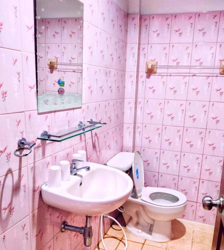 a pink bathroom with a sink and a toilet at นาหินลาดรีสอร์ท Nahinlad Resort in Ban Khok Sawang (2)