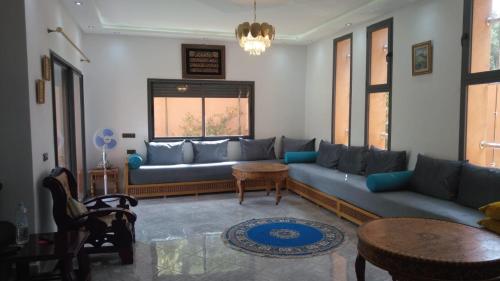 a living room with a blue couch and a table at Villa isouktan in Sbiti