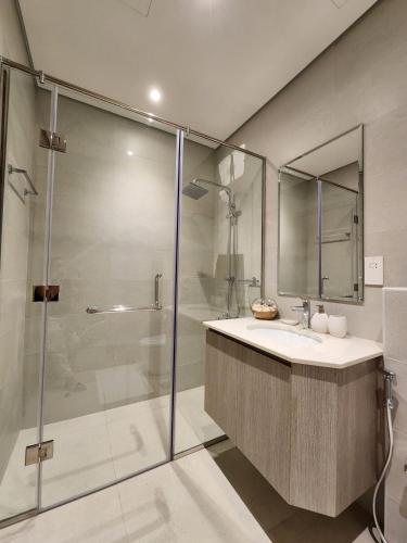 Un baño con lavabo y ducha de cristal. en Nasma Luxury Stays - Lakeside Retreat Stylish & Cozy Villa Stay, en Ras al Khaimah