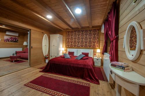 a bedroom with a red bed in a room with wooden walls at Lakeside Hotel Plitvice in Plitvička Jezera