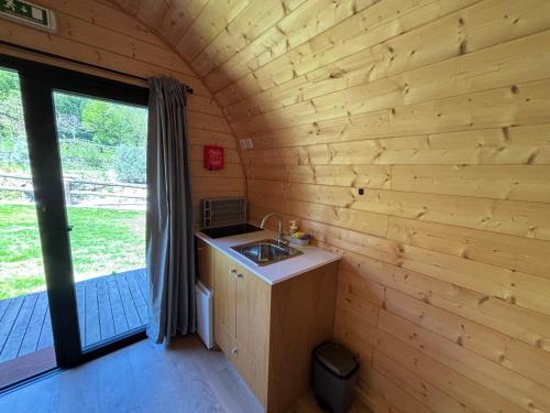 a kitchen in a log cabin with a sink at Gerês Wood Valley in Geres