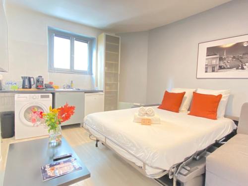 une chambre d'hôpital avec un lit avec des oreillers orange dans l'établissement GuestReady - Cozy green haven in Paris 13, à Paris
