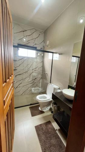 a bathroom with a toilet and a sink at Refúgio Pé da Serra - Chalés in São Roque de Minas