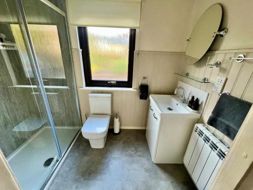 a bathroom with a toilet and a shower and a sink at Clianba- 3 bedroom Highland home from home in Spean Bridge