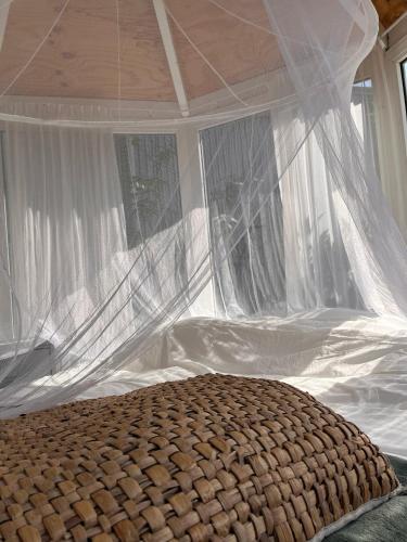a bedroom with a bed with a mosquito net at DE BUITENKANS urban camping - unique cabins in Rotterdam