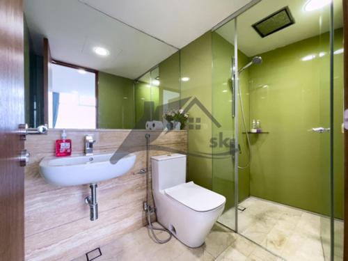a green bathroom with a toilet and a sink at Vortex Residence KLCC ,12 Jalan Sultan Ismail Kuala Lumpur in Kuala Lumpur