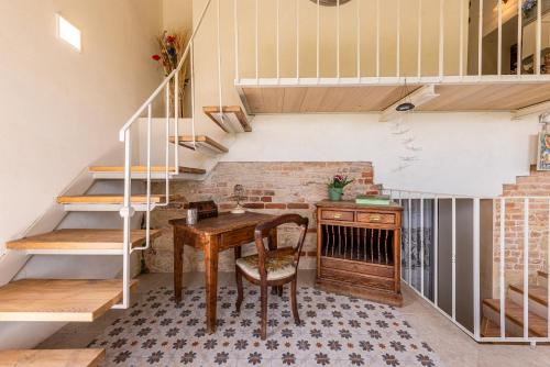 a room with a wooden table and a staircase at Le libellule relais in San Lorenzo