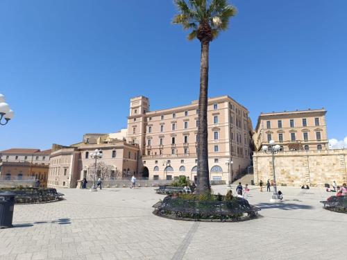 a palm tree in front of a large building at Regina House al centro di Cagliari in Cagliari