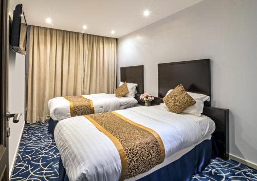 a hotel room with two beds and a window at كروان لـلشـقق المخدومه حي الفيصلية التحليه Carawan Serviced Apartment ALFAISLIYA Altahliya in Jeddah